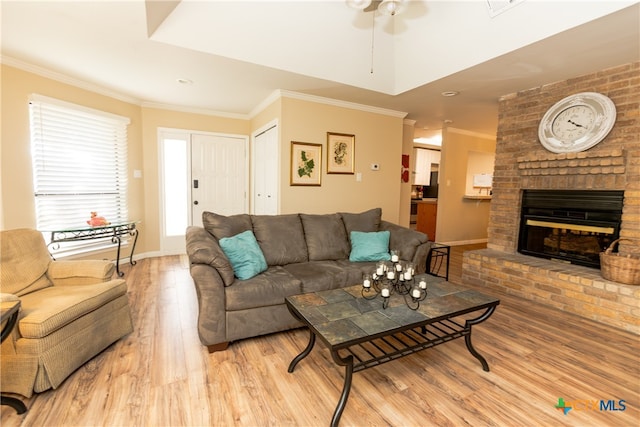 living room featuring a fireplace, ceiling fan, light hardwood / wood-style flooring, and ornamental molding