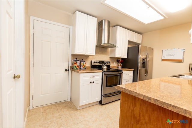 kitchen featuring white cabinets, stainless steel appliances, wall chimney range hood, and backsplash