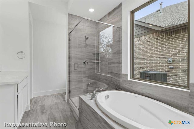 bathroom featuring vanity and shower with separate bathtub