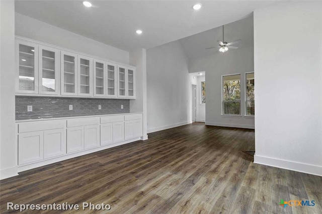 unfurnished living room featuring dark hardwood / wood-style floors, ceiling fan, and high vaulted ceiling