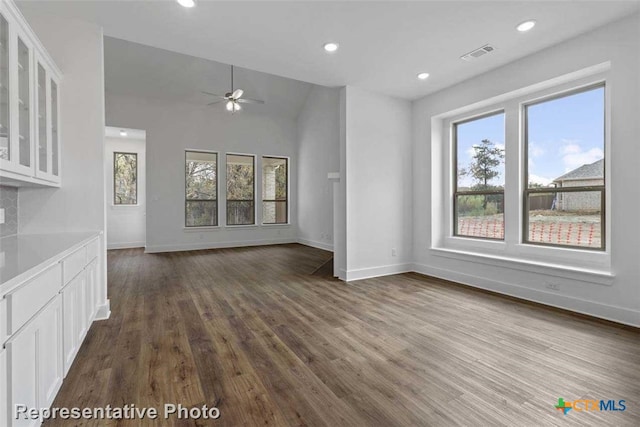 unfurnished living room with ceiling fan, dark hardwood / wood-style flooring, and vaulted ceiling