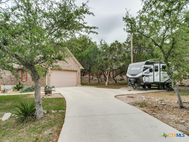 1777 Crossbow Dr, Canyon Lake, TX 78133 - exterior space featuring brick siding, an attached garage, and concrete driveway