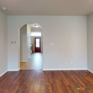 5120 Siltstone Loop, Killeen, TX 76542 - unfurnished room featuring arched walkways, baseboards, and wood finished floors