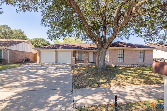 ranch-style home with central air condition unit, a garage, and a front lawn