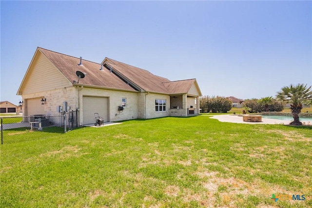 490 Wellspring Blvd, Victoria, TX 77904 - rear view of property featuring an attached garage, fence, brick siding, a lawn, and an outdoor fire pit