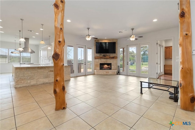 211 Scarlett Ridge Dr, Boerne, TX 78006 - unfurnished living room featuring recessed lighting, a large fireplace, a sink, light tile patterned flooring, and ceiling fan