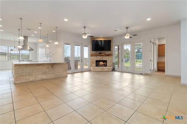 211 Scarlett Ridge Dr, Boerne, TX 78006 - unfurnished living room featuring plenty of natural light, recessed lighting, a fireplace, light tile patterned floors, and a ceiling fan