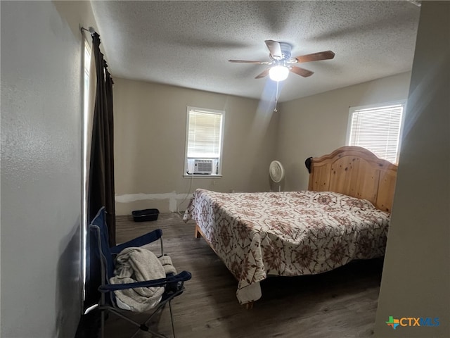 bedroom with a textured ceiling, ceiling fan, cooling unit, and wood finished floors