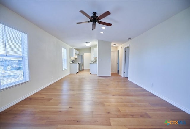 unfurnished living room featuring light hardwood / wood-style flooring, vaulted ceiling, and ceiling fan