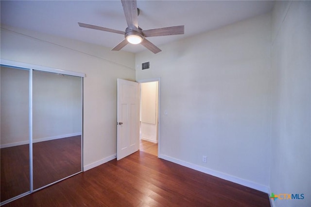 unfurnished bedroom featuring a closet, ceiling fan, and dark hardwood / wood-style floors