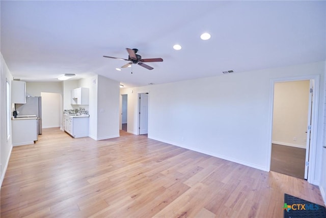 unfurnished living room with light wood-type flooring and ceiling fan