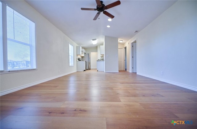 unfurnished living room featuring light wood-type flooring, vaulted ceiling, and ceiling fan