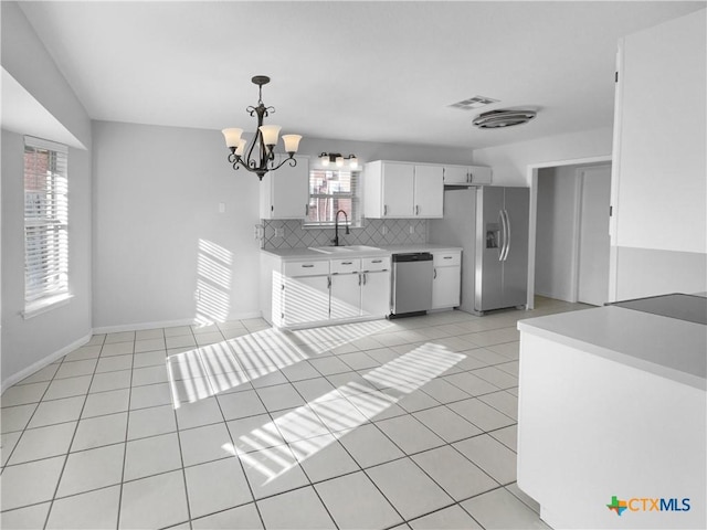 kitchen with appliances with stainless steel finishes, sink, decorative light fixtures, an inviting chandelier, and white cabinets