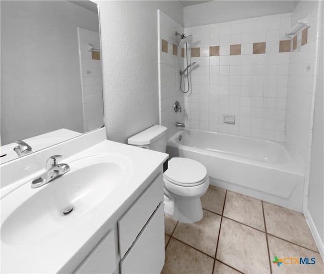 full bathroom with tile patterned floors, tiled shower / bath, vanity, and toilet