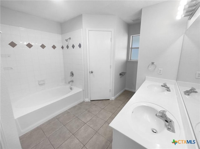 bathroom with tile patterned flooring, tiled shower / bath combo, and vanity