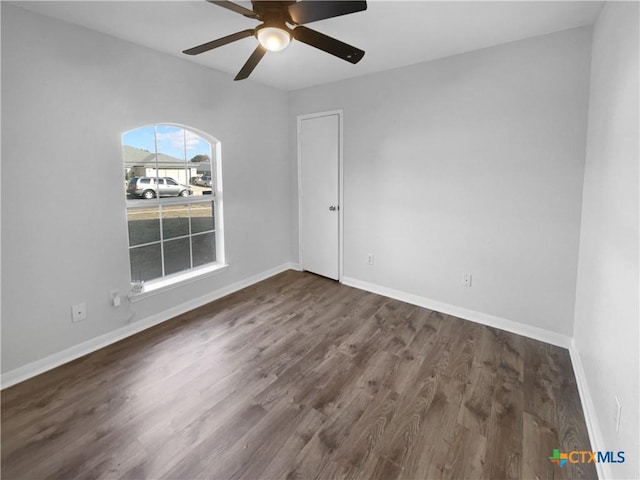 empty room with ceiling fan and dark hardwood / wood-style floors