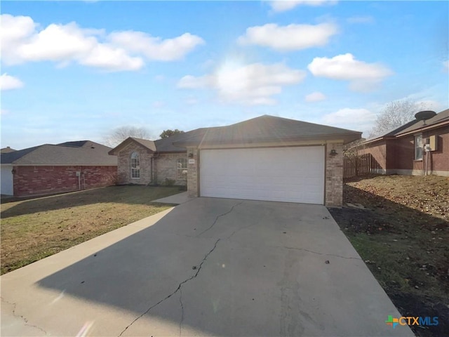 ranch-style house featuring a garage and a front lawn