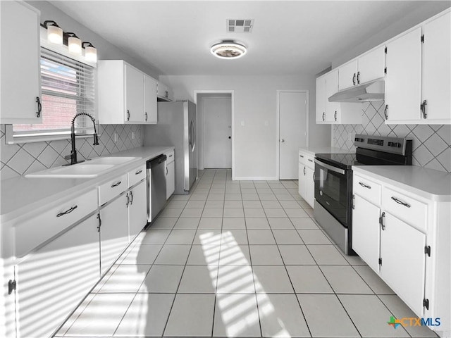 kitchen featuring appliances with stainless steel finishes, tasteful backsplash, white cabinetry, and sink