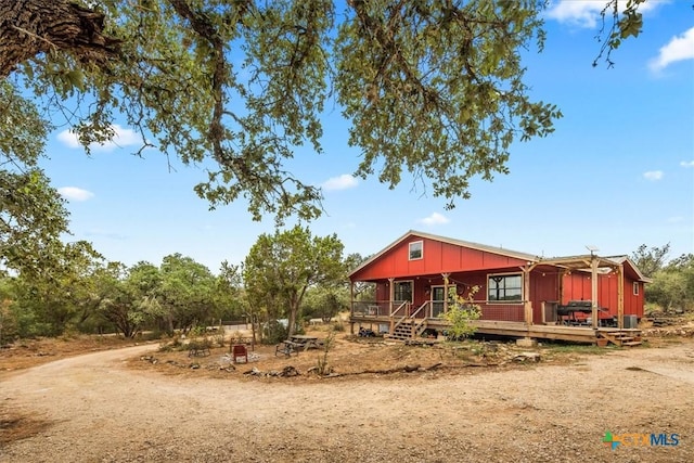 view of front of house featuring board and batten siding, driveway, and a porch