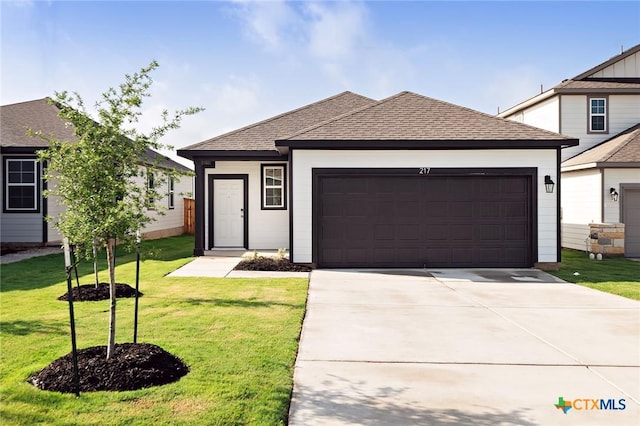 217 Alcatraz Loop, Jarrell, TX 76537 - view of front of house featuring an attached garage, driveway, a front lawn, and roof with shingles