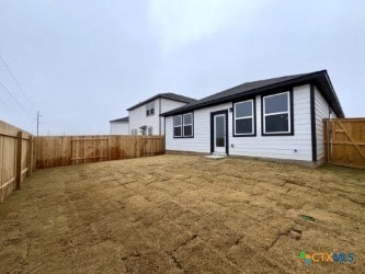 rear view of property featuring a yard