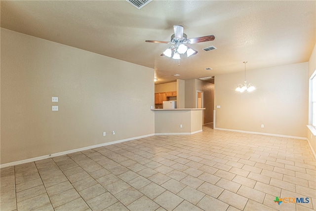 spare room featuring a textured ceiling and ceiling fan with notable chandelier