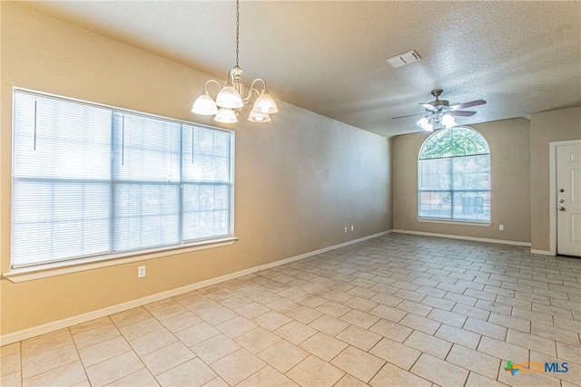 tiled spare room with ceiling fan with notable chandelier and a textured ceiling