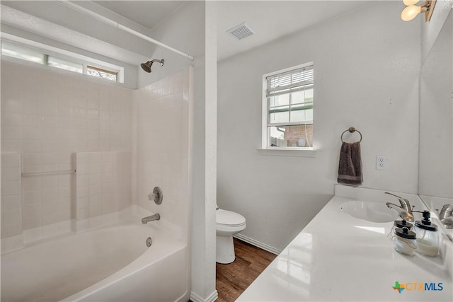 full bathroom with hardwood / wood-style flooring, vanity, toilet, and shower / tub combination