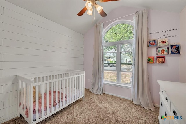 carpeted bedroom with ceiling fan, a crib, multiple windows, and lofted ceiling