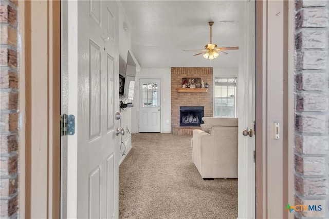 carpeted living room featuring ceiling fan and a brick fireplace