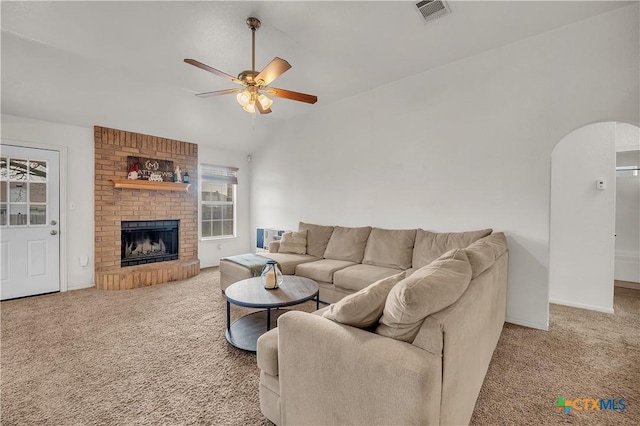 carpeted living room featuring ceiling fan, a fireplace, and lofted ceiling