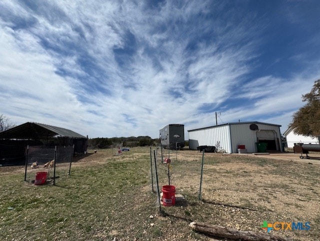 view of yard with a garage, an outbuilding, and an outdoor structure