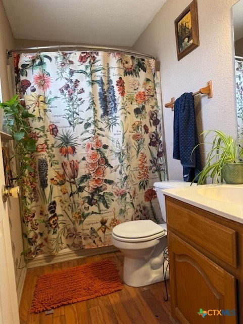 bathroom featuring vanity, a shower with shower curtain, toilet, and wood finished floors