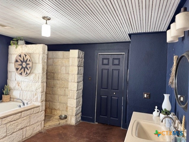 bathroom featuring concrete floors, a garden tub, and a sink