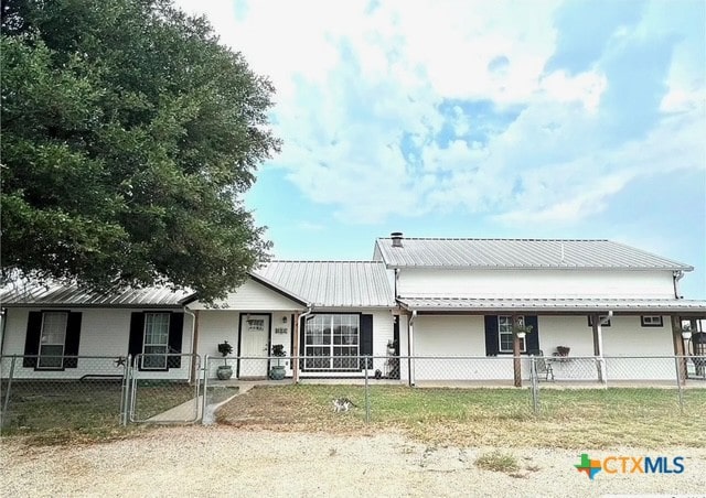 view of front of house featuring a fenced front yard, metal roof, and a gate