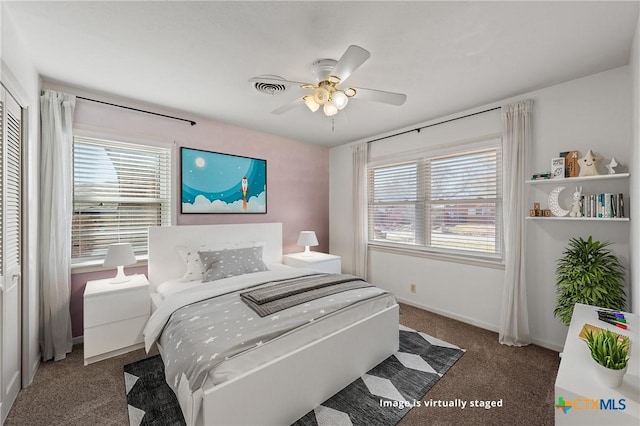 carpeted bedroom featuring multiple windows, a closet, a ceiling fan, and baseboards