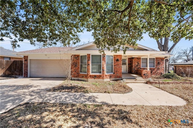 ranch-style house featuring a garage, driveway, brick siding, and fence