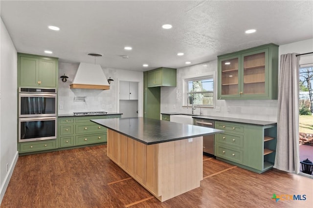 kitchen with premium range hood, appliances with stainless steel finishes, and green cabinets