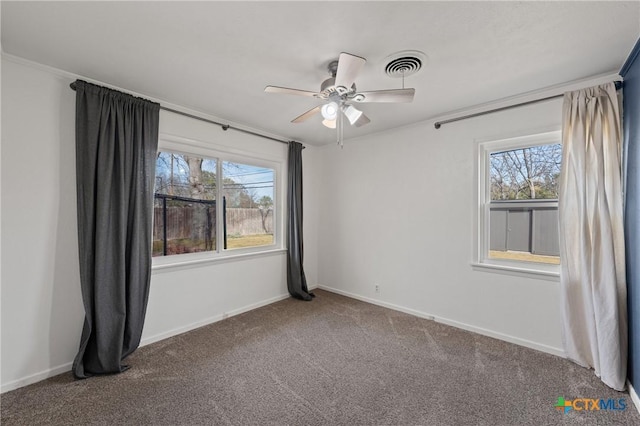 unfurnished room featuring plenty of natural light, carpet, visible vents, and baseboards