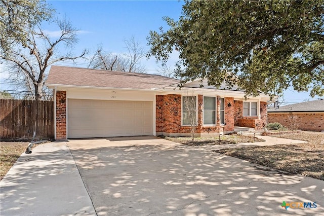 ranch-style house with a garage, brick siding, fence, and driveway