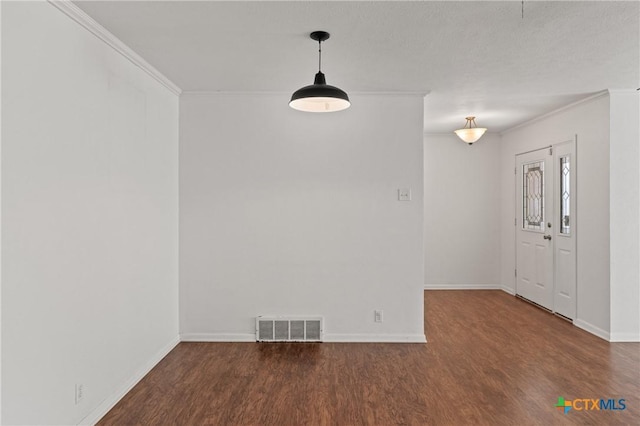 unfurnished dining area featuring ornamental molding, wood finished floors, visible vents, and baseboards