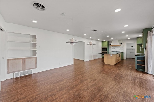 kitchen featuring visible vents, dark wood finished floors, and premium range hood