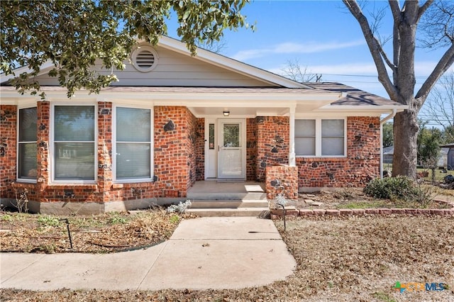 bungalow featuring brick siding