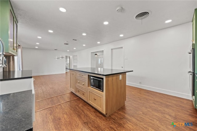 kitchen with visible vents, open floor plan, dark wood-style flooring, built in microwave, and recessed lighting