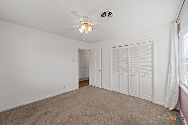 unfurnished bedroom featuring carpet floors, baseboards, visible vents, and a closet