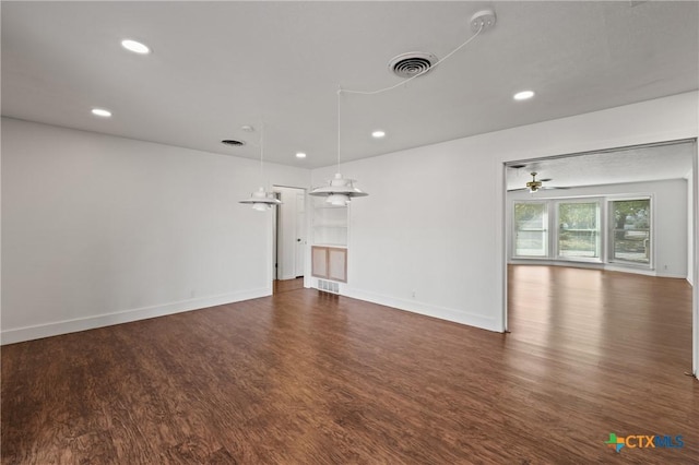 unfurnished living room featuring recessed lighting, visible vents, dark wood finished floors, and baseboards