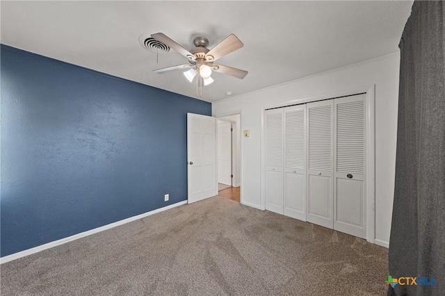 unfurnished bedroom featuring a closet, visible vents, carpet flooring, ceiling fan, and baseboards