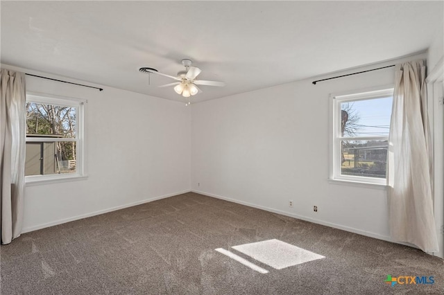 carpeted spare room featuring ceiling fan and baseboards