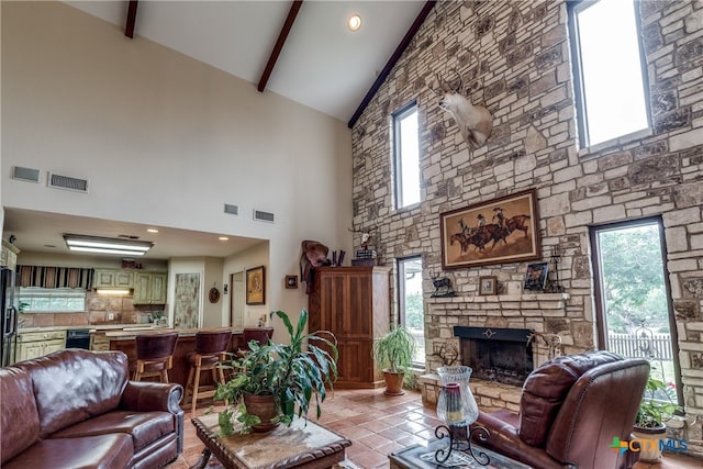 living room featuring high vaulted ceiling, a fireplace, light tile patterned flooring, and beam ceiling