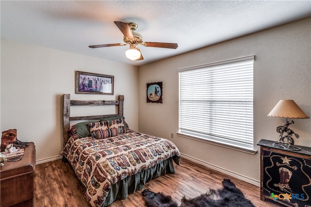 bedroom with dark wood-type flooring, a textured ceiling, and ceiling fan